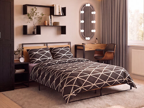 Chambre moderne avec un lit plateforme en m&eacute;tal noir et bois, habill&eacute; d'une parure de lit noire et blanche &agrave; motif g&eacute;om&eacute;trique, accompagn&eacute; d'une table de chevet assortie avec un r&eacute;veil au style vintage. Une grande armoire en bois fonc&eacute; se trouve &agrave; c&ocirc;t&eacute; d'&eacute;tag&egrave;res murales flottantes noires d&eacute;cor&eacute;es de livres, de plantes et d'objets d&eacute;coratifs. En face du lit, une coiffeuse minimaliste en bois avec une structure noire est associ&eacute;e &agrave; une chaise incurv&eacute;e en noyer et &agrave; un miroir ovale dot&eacute; d'un &eacute;clairage int&eacute;gr&eacute;. De longs rideaux gris du sol au plafond encadrent une grande fen&ecirc;tre qui baigne la pi&egrave;ce de lumi&egrave;re naturelle chaleureuse, tandis qu'un tapis moelleux couleur cr&egrave;me et un parquet en bois clair cr&eacute;ent une ambiance chaleureuse et contemporaine.