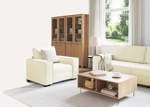 Canap&eacute; blanc 2 places avec coussins et plaid, &agrave; l'int&eacute;rieur.