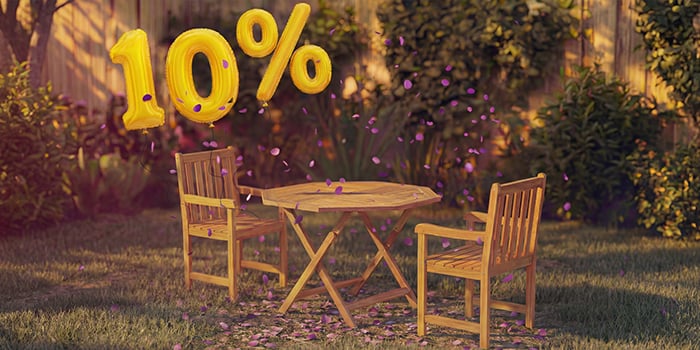 Table à manger d’extérieur en bois avec deux chaises assorties dans un cadre de jardin, décorée de confettis roses et de ballons dorés « 10 % de réduction », mettant en avant une promotion saisonnière sur le mobilier de repas d’extérieur.
