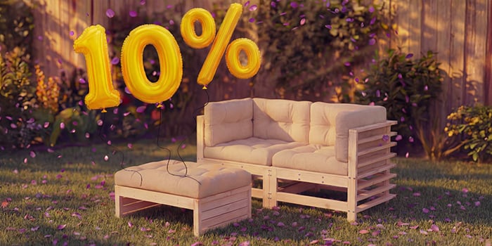 Canapé lounge d’extérieur en bois avec coussins beiges et repose-pieds assorti dans un cadre de jardin, entouré de confettis roses et de ballons dorés « 10 % de réduction », mettant en avant une vente saisonnière sur les meubles d’assise d’extérieur.